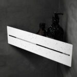 Elegancka, biała półka ścienna o nowoczesnym, minimalistycznym designie. Wykonana z wytrzymałego metalu, cechuje się wysoką jakością i odpornością na wilgoć, co czyni ją idealnym rozwiązaniem do łazienek. Subtelny wycięty wzór na środku dodaje lekkości konstrukcji, jednocześnie umożliwiając funkcjonalne odprowadzanie wody. Dzięki prostemu systemowi montażu na ścianie i uniwersalnemu stylowi, półka doskonale wpasowuje się w różnorodne aranżacje wnętrz, od nowoczesnych po skandynawskie.