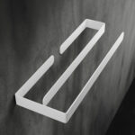 Biały, minimalistyczny wieszak na ręczniki wykonany z aluminium, zamocowany na ciemnoszarej, betonowej ścianie. Wieszak ma prostą, geometryczną formę z dwoma równoległymi poprzeczkami, które tworzą funkcjonalną przestrzeń do zawieszania ręczników. Matowe wykończenie podkreśla nowoczesny, elegancki design, idealnie komponując się z surowym tłem ściany.
