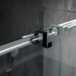Dwustronny haczyk na kabinę prysznicową w kolorze czarnym zawieszony na kabinie wykonanej z szkła w tle nowoczesnej elegancje łazienki