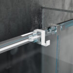 Dwustronny haczyk na kabinę prysznicową w kolorze białym zawieszony na kabinie wykonanej z szkła w tle nowoczesnej elegancje łazienki
