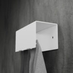 Biały, minimalistyczny wieszak na ręczniki HUKI wykonany z malowanej proszkowo stali, montowany do ściany – widok z boku na prostokątną formę z zaokrąglonymi krawędziami i otworami montażowymi.