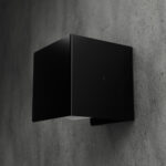 Czarny, metalowy uchwyt na papier toaletowy Nira, zamontowany na betonowej ścianie w nowoczesnej łazience – minimalistyczny design w stylu industrialnym