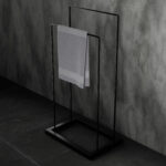 Stojak łazienkowy wolnostojący w kolorze matowej czerni, o prostym, geometrycznym kształcie. Minimalistyczna konstrukcja z dwiema poprzeczkami idealna do suszenia ręczników.