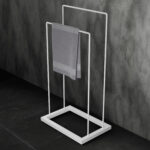 Stojak łazienkowy wolnostojący w kolorze matowej bieli, o prostym, geometrycznym kształcie. Minimalistyczna konstrukcja z dwiema poprzeczkami idealna do suszenia ręczników.