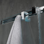 Dwustronny haczyk na kabinę prysznicową w kolorze białym zawieszony na kabinie wykonanej z szkła w tle nowoczesnej elegancje łazienki