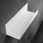 Czarna półka łazienkowa samoprzylepna z matowego metalu, pokryta kroplami wody. Na półce ustawione są dwie butelki kosmetyków – większa z pompką i mniejsza z zakrętką. Półka ma prostokątny kształt z pełnymi bokami i perforowanym spodem umożliwiającym odpływ wody.