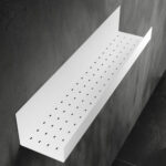 Czarna półka łazienkowa samoprzylepna z matowego metalu, pokryta kroplami wody. Na półce ustawione są dwie butelki kosmetyków – większa z pompką i mniejsza z zakrętką. Półka ma prostokątny kształt z pełnymi bokami i perforowanym spodem umożliwiającym odpływ wody.