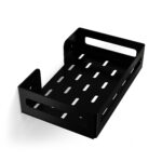 Czarna metalowa półka łazienkowa NAOS z matowym wykończeniem, zamontowana na ścianie, z perforowanym dnem i wysokimi bokami; na półce ustawione butelki kosmetyków.