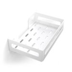 Biała metalowa półka łazienkowa NAOS z matowym wykończeniem, zamontowana na ścianie, z perforowanym dnem i wysokimi bokami; na półce ustawione butelki kosmetyków.