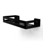 Czarna metalowa półka łazienkowa NAOS z matowym wykończeniem, zamontowana na ścianie, z perforowanym dnem i wysokimi bokami; na półce ustawione butelki kosmetyków.