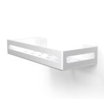 Biała metalowa półka łazienkowa NAOS z matowym wykończeniem, zamontowana na ścianie, z perforowanym dnem i wysokimi bokami; na półce ustawione butelki kosmetyków.