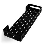 Czarna metalowa półka łazienkowa NAOS z matowym wykończeniem, zamontowana na ścianie, z perforowanym dnem i wysokimi bokami; na półce ustawione butelki kosmetyków.