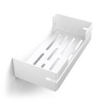 Biała, metalowa półka łazienkowa VEGA z matowym wykończeniem, zamontowana na ścianie, z widocznymi kroplami wody. Na półce ustawione są eleganckie kosmetyki w ciemnych butelkach. Konstrukcja posiada perforowane dno dla odpływu wody oraz wysokie boki zabezpieczające przed zsuwaniem się przedmiotów.