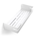 Biała, metalowa półka łazienkowa VEGA z matowym wykończeniem, zamontowana na ścianie, z widocznymi kroplami wody. Na półce ustawione są eleganckie kosmetyki w ciemnych butelkach. Konstrukcja posiada perforowane dno dla odpływu wody oraz wysokie boki zabezpieczające przed zsuwaniem się przedmiotów.