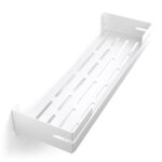 Biała, metalowa półka łazienkowa VEGA z matowym wykończeniem, zamontowana na ścianie, z widocznymi kroplami wody. Na półce ustawione są eleganckie kosmetyki w ciemnych butelkach. Konstrukcja posiada perforowane dno dla odpływu wody oraz wysokie boki zabezpieczające przed zsuwaniem się przedmiotów.