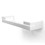 Biała, metalowa półka łazienkowa VEGA z matowym wykończeniem, zamontowana na ścianie, z widocznymi kroplami wody. Na półce ustawione są eleganckie kosmetyki w ciemnych butelkach. Konstrukcja posiada perforowane dno dla odpływu wody oraz wysokie boki zabezpieczające przed zsuwaniem się przedmiotów.