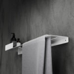 Nowoczesna biała półka łazienkowa Orion z wbudowanym uchwytem na ręcznik. Wykonana z metalu, o minimalistycznej, geometrycznej formie.