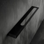 Nowoczesna czarna półka łazienkowa Orion z wbudowanym uchwytem na ręcznik. Wykonana z metalu, o minimalistycznej, geometrycznej formie.