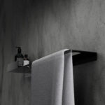 Nowoczesna czarna półka łazienkowa Orion z wbudowanym uchwytem na ręcznik. Wykonana z metalu, o minimalistycznej, geometrycznej formie.