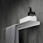 Nowoczesna biała półka łazienkowa Orion z wbudowanym uchwytem na ręcznik. Wykonana z metalu, o minimalistycznej, geometrycznej formie.