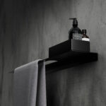Nowoczesna czarna półka łazienkowa Orion z wbudowanym uchwytem na ręcznik. Wykonana z metalu, o minimalistycznej, geometrycznej formie.