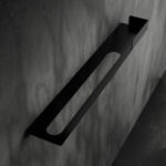 Nowoczesna czarna półka łazienkowa Orion z wbudowanym uchwytem na ręcznik. Wykonana z metalu, o minimalistycznej, geometrycznej formie.